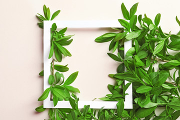 Frame with green leaves on light background