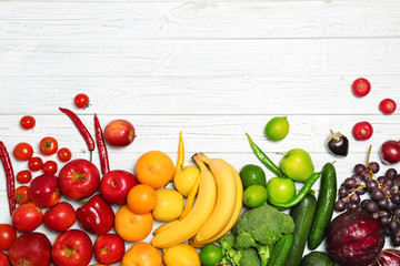 Rainbow composition with fresh vegetables and fruits on wooden background, flat lay