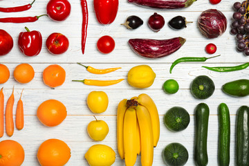 Rainbow composition with fresh vegetables and fruits on wooden background, flat lay