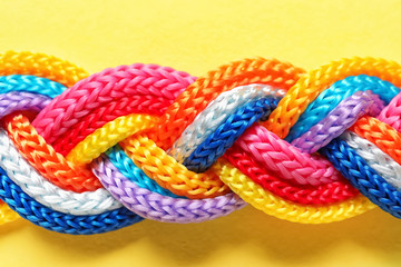 Braided ropes on color background, top view. Unity concept