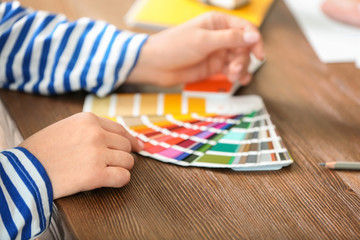 Female designer working with color palette samples at table