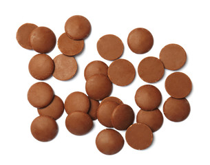 Delicious milk chocolate chips on white background, top view