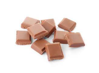 Delicious milk chocolate pieces on white background