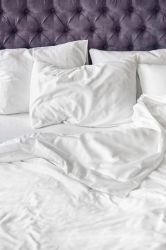 Comfortable bed with white linen at home