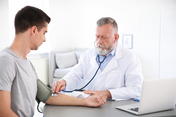Obraz premium Doctor measuring patient's blood pressure in hospital