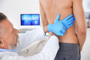 Urologist in gloves examining young patient in clinic
