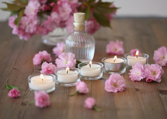 Fototapeta na wymiar Burning candles and sakura blossoms