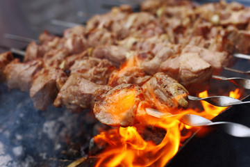 Barbecue in nature in summer. Pork meat in the smoke on the coals, healthy food, closeup.