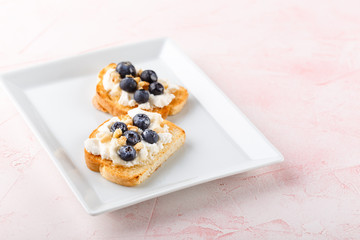 Toast with fresh berries blueberry Ricotta cheese, thyme, honey and hazelnuts, served