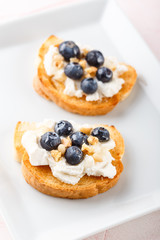 Toast with fresh berries blueberry Ricotta cheese, thyme, honey and hazelnuts, served