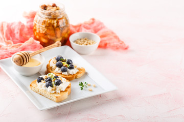 Toast with fresh berries blueberry Ricotta cheese, thyme, honey and hazelnuts, served