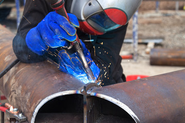 Worker welding in a factory. Welding on an industrial plant.