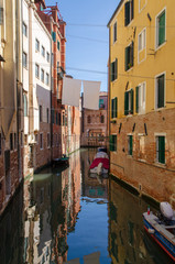 Fototapeta na wymiar Venetian canal with boats and reflections