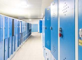Blaue Spinde und Vorhängeschloss in der Schule, Umkleide