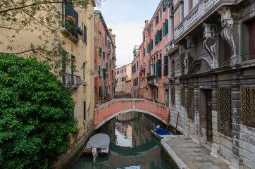 Fototapeta na wymiar Venetian canal in the morning and view of the typical architecture with colorful houses, Italy