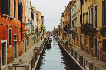 Fototapeta na wymiar Romantic view of a canal in Venice with some boats and a sunny light, Italy
