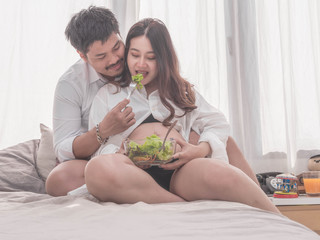 Pregnancy healthy food and people concept.future dad and mom eating healthy salad and take care together.