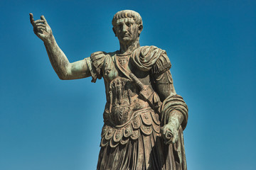 Obraz premium Rzym, brązowa statua cesarza Cezara Nervae Trajana, w tle Forum Cezara Nervae Trajana