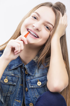 Dental Health Concepts.Portrait of Blond Caucasian Teenage Girl With Teeth Braces. Cleaning Brackets using Bristle Brush.