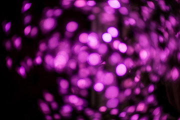 Purple bokeh abstract background on a dark background.