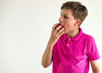 boy biting a red apple on white background