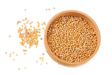 mustard seeds in wooden bowl isolated on white background. top view