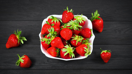 strawberry in a white plate on a black background