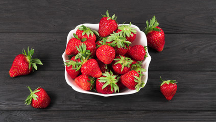 strawberry in a white plate on a black background