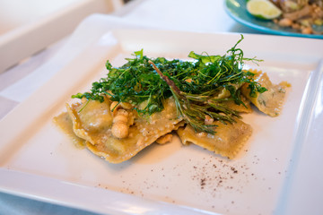 Ravioli with ricotta cheese, rucola and hazelnuts in italian restaurant