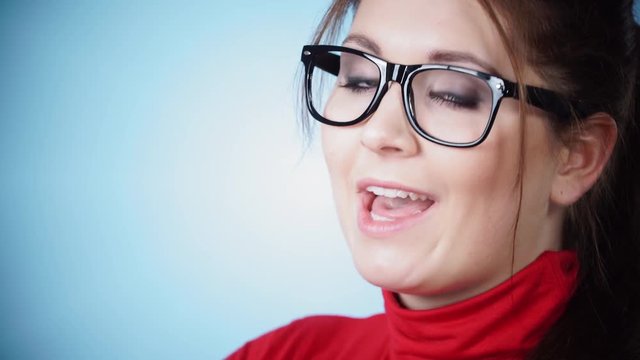 Young woman in glasses talking to camera ok and agrees, on blue. Expression of agreement 4K ProRes HQ codec