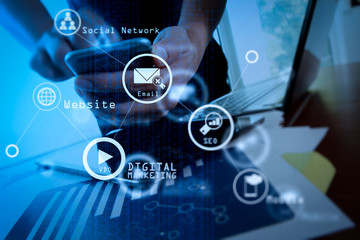 business documents on office table with smart phone and digital tablet and man working in the background