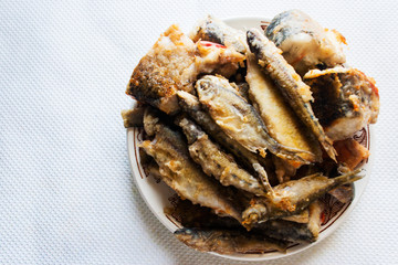 Fried river fish on a plate. Candid.
