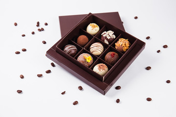 handmade chocolates in a square box and coffee beans near