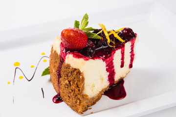 Cheesecake with jam garnished with strawberries and mint leaves