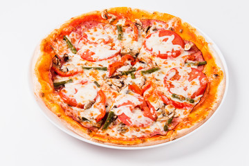 Pizza with tomato, mushrooms, bell peppers on a white plate on a light background
