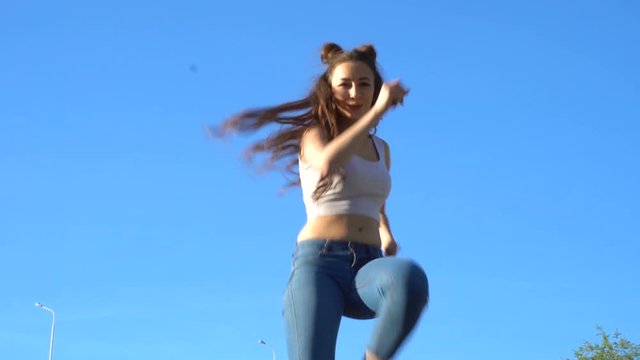 Dancer Woman. Young sexy girl dances outdoor against blue sky