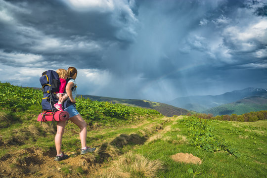 Mother hiker with baby enjoy the stormy sky