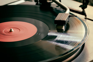 The stylus of the vinyl analog player is in contact with the surface of the rotating LP. Close up....