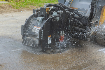 Asphalt milling machine working on city street Road construction machine breaks up © ungvar