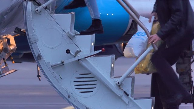 Passengers climb the ladder into the airplane