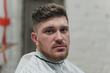 Obraz premium A man in a barber shop for haircuts and shaving