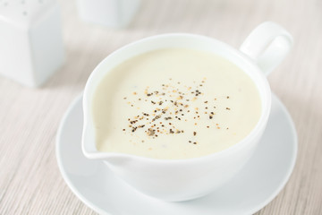 Frische hausgemachte Bechamelsauce aus Butter, Mehl und Milch, eine klassiche helle Grundsauce (Selektiver Fokus, Fokus in die Mitte des Bildes)