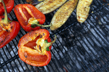 Close-up red pepper and slices of eggplant are grilled. Open fire kitchen. BBQ Restaurant. Red grilled pepper on bbq fireplace
