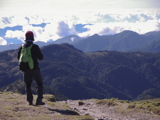 A male hiker standing on a platform and enjoying the beautiful alpine landscape of Taiwan.