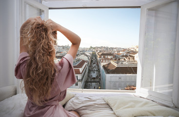 Woman looking at view from a window in hotel room