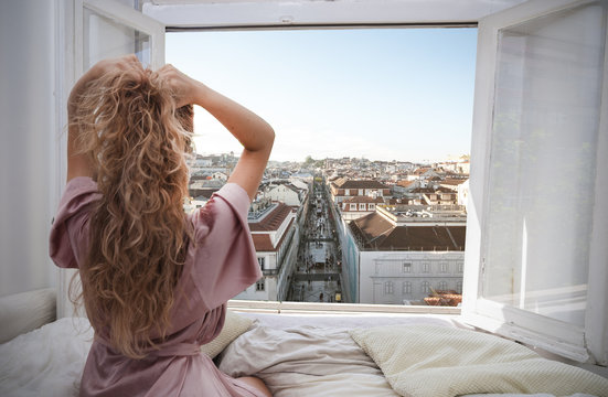 Woman Looking At View From A Window In Hotel Room