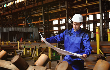 Engineer-builder working with documents on the construction site. Worker inspects drawings on the...