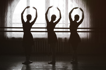 Obraz premium graceful silhouettes of ballerinas in the background of a window in ballet class