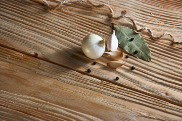 Garlic, onion, bay leaf, black pepper on a wooden table. Food background. Garlics. sliced garlic, garlic clove, garlic bulb.