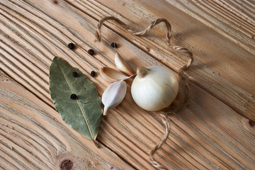 Garlic, onion, bay leaf, black pepper on a wooden table. Food background. Garlics. sliced garlic, garlic clove, garlic bulb.